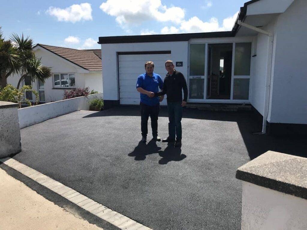 Shaking hands with a customer on tarmac driveway